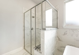A white bathroom with a glass shower stall.