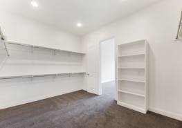 An empty walk in closet with shelves and shelves.