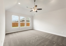 Empty room with gray carpet and ceiling fan.