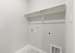 A small closet with a white shelf and a white floor.