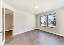 An empty room with hardwood floors and a window.
