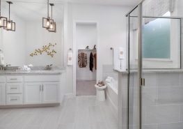 A white bathroom with a walk in shower.