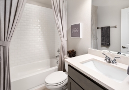 A bathroom with a white shower curtain and sink.