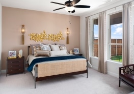 A bedroom with a bed and a ceiling fan.