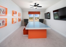 A home office with an orange and white desk.