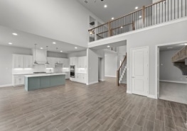 An empty kitchen with hardwood floors and a staircase.