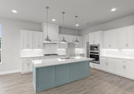 A kitchen with white cabinets and a blue island.