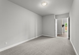 An empty room with gray walls and carpet.