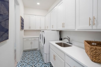 A white and blue laundry room with a washer and dryer.