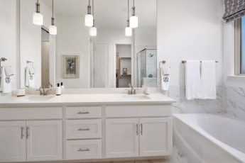 A white bathroom with two sinks and a tub.
