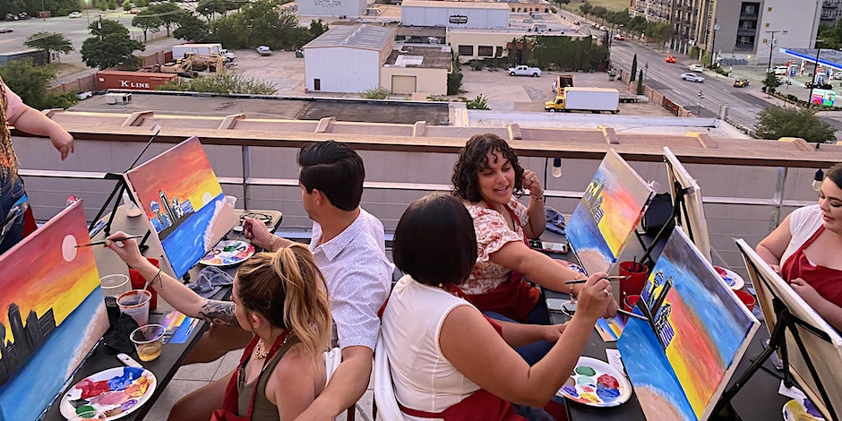 A group of people painting on a rooftop.