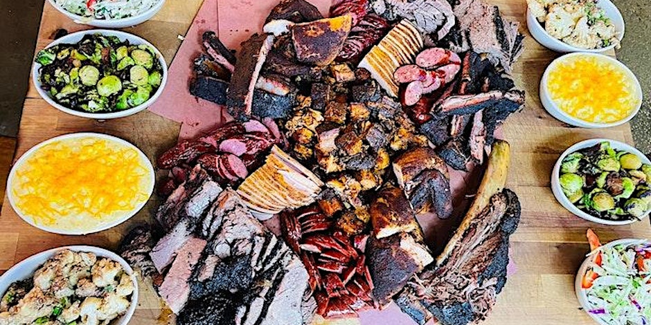 A large platter of bbq food on a wooden table.