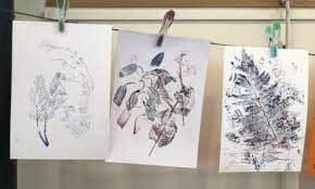 A group of drawings hanging on a clothes line.